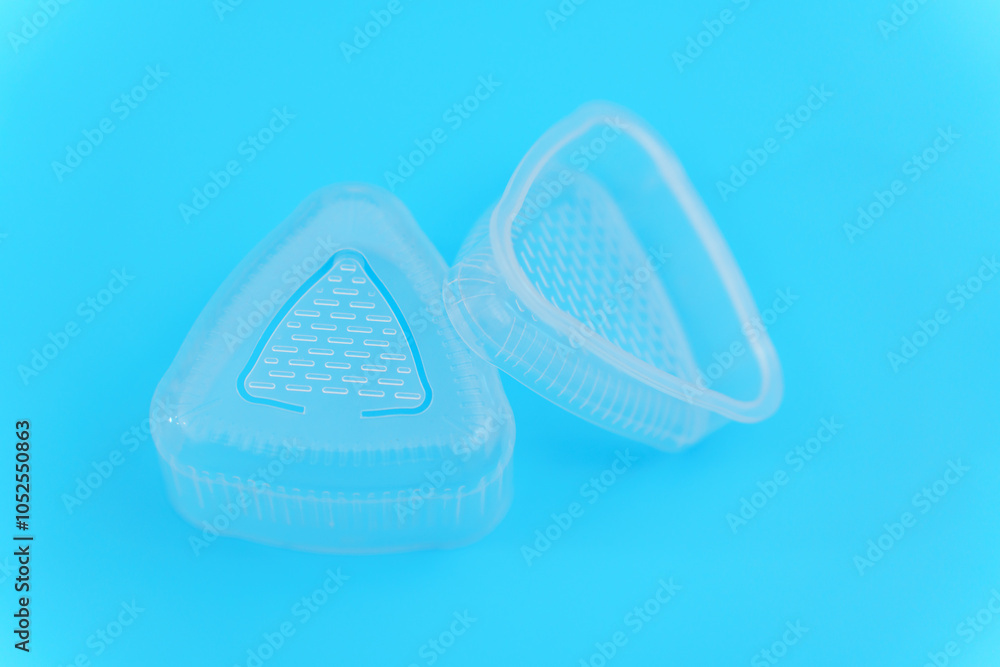 Plastic Triangular Onigiri Molds on a blue background. A simple and delicious Asian snack meal. Plastic Triangular Onigiri Molds on a blue background. A simple and delicious Asian snack meal.