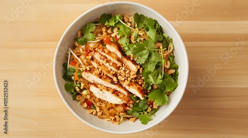 Classic Pad Thai with tender chicken strips, isolated on a light wooden surface, garnished with cilantro, crushed peanuts, and bean sprouts photo