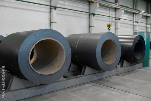 Painted rolled metal coils are stored at the factory