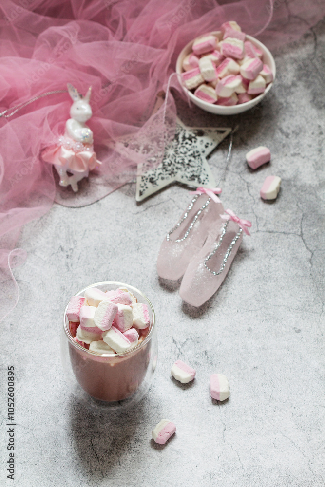 Cocoa with marshmallows, Christmas tree decorations and pink tulle on a concrete background.