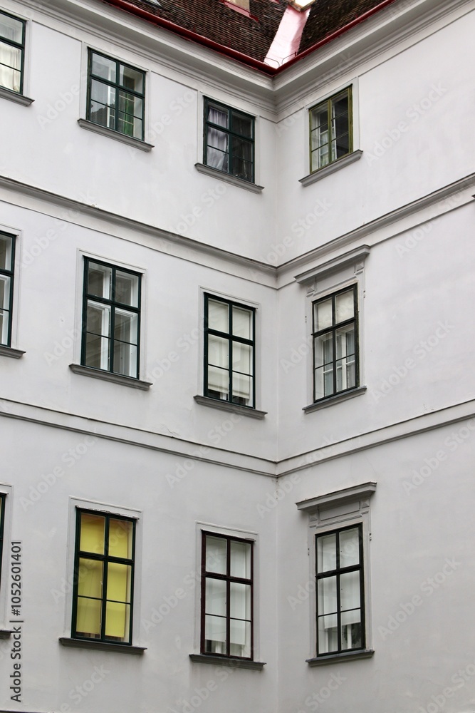 Obraz premium Minimalist Corner of Historic European Building with Symmetrical Windows – For Architectural Design and Urban Development Projects. Vienna, Austria