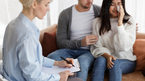 Couples Therapy. Husband Comforting Crying Wife During Session With Psychologist Sitting On Sofa In Office. Selective Focus, Cropped