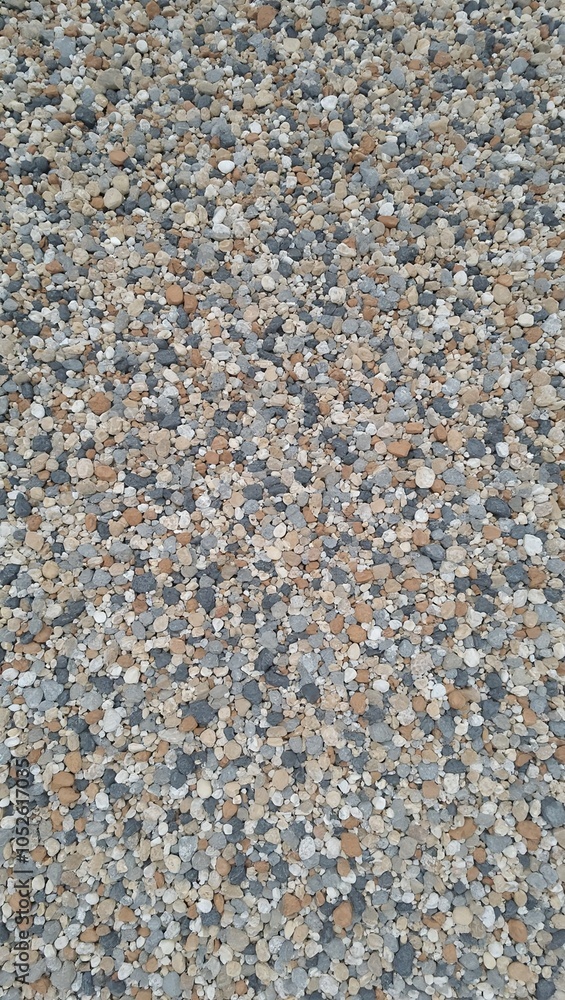 Textured pebble covered wall in gray white and tan tones Textured pebble covered wall in gray white and tan tones