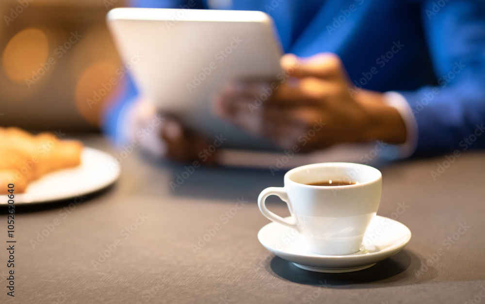 Coffee Break. Unrecognizable afro guy using tablet computer at cafe and drinking coffee, focus on cup, copyspace Coffee Break. Unrecognizable afro guy using tablet computer at cafe and drinking coffee, focus on cup, copyspace