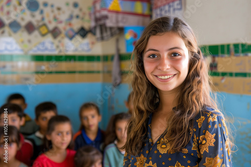 Photography of Algeria school classroom scene with children in background and the teacher on front.	
