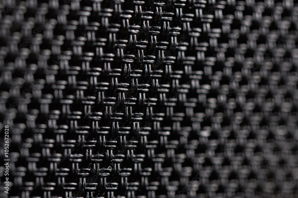 Close-up view of the texture black weave fiber. The intricate weave pattern creates a strong and lightweight structure. Abstract backround, wallpaper. Close-up view of the texture black weave fiber. The intricate weave pattern creates a strong and lightweight structure. Abstract backround, wallpaper.