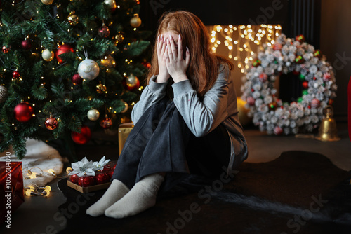 Young beautiful depressed and sad girl sitting alone for Christmas Eve