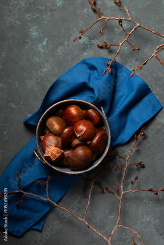 Obraz na płótnie A bowl with edible chestnuts stands on a blue cloth w salonie