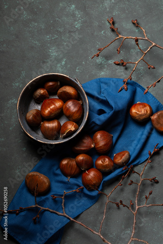 Obraz na płótnie A bowl with edible chestnuts stands on a blue cloth w salonie