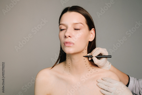 Foto Cosmetologist is drawing dotes before botulinum toxin injection in platysma of a woman