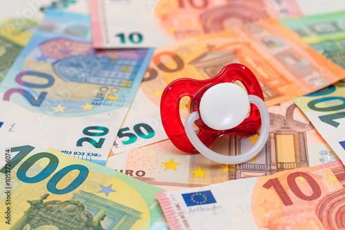 Childfree, Contraception and Birth Control Concept: Baby Pacifier on the Euro Banknotes. Having Children is Expensive and Unprofitable