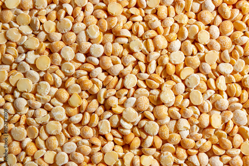 Uncooked Polished Split Peas Background. A Culinary Canvas of Dry Yellow Peas, Creating a Lively and Textured Background for Gourmet Cooking. Scattered Raw Polished Peas. Healthy Eating Ingredients