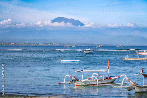 Top of mount Agung volcano panorama view from Sanur beach Bali Indonesia, only part of volcano is visible, many longtail boats at foreground. photo