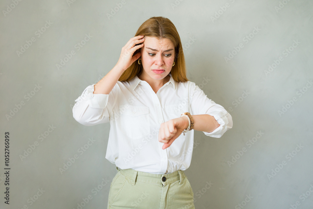 Young woman is checking the time and feeling stressed because she is running late Young woman is checking the time and feeling stressed because she is running late