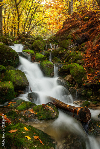 Beautiful waterfall between rocks covered in moss in Serra da Estrela in Portugal in autumn.
