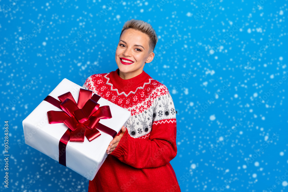 Photo of cheerful thankful girl wear trendy old ugly new year sweater hold big gift box from online santa claus delivery isolated on blue color background Photo of cheerful thankful girl wear trendy old ugly new year sweater hold big gift box from online santa claus delivery isolated on blue color background