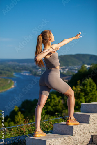Fitness portrait young athletic woman doing gymnastics on blue sky background