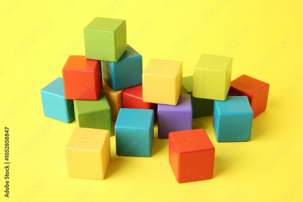 Obraz premium Many wooden colorful cubes on yellow background
