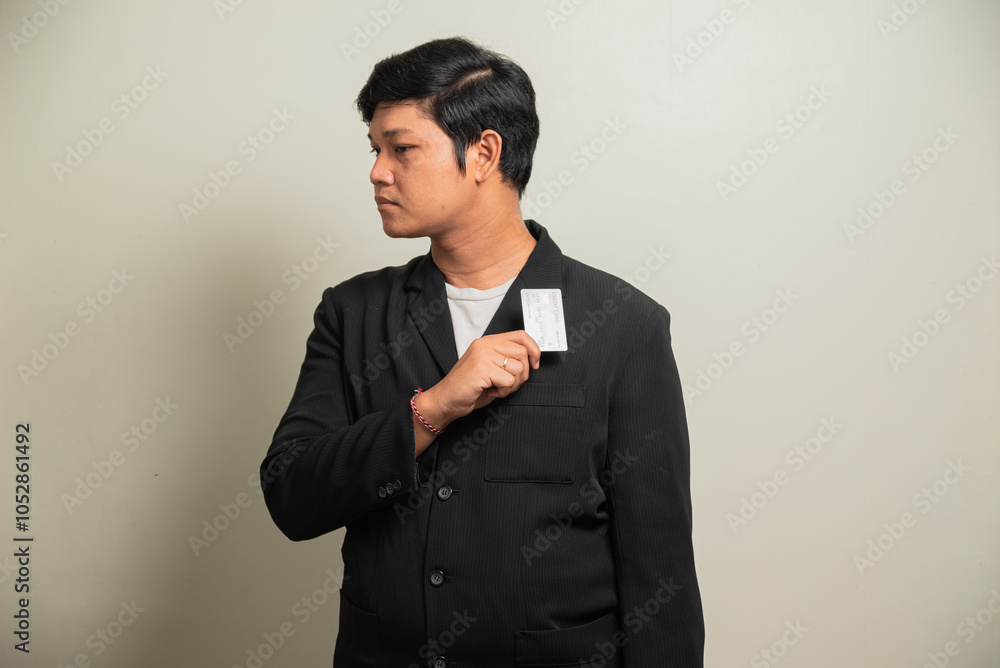 Young handsome man over isolated grey background holding a credit card Young handsome man over isolated grey background holding a credit card