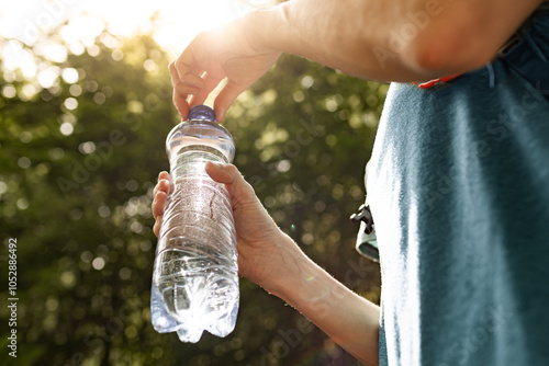 Obraz na plátně person holding water bottle, drinking water, body care health concept