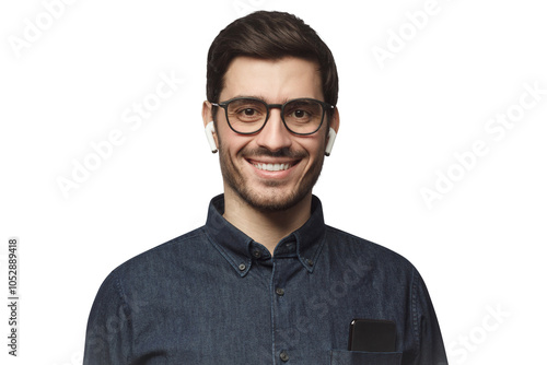 Portrait of young smiling man listeting to his favorite music track with earphones, wearing blue denim shirt and glasses photo