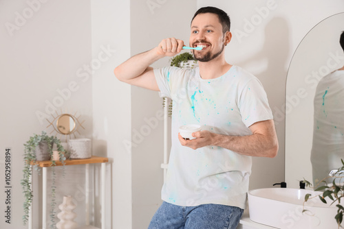 Smiling young man brushing ...