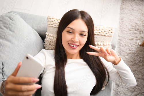 Young Asian woman with mobi...