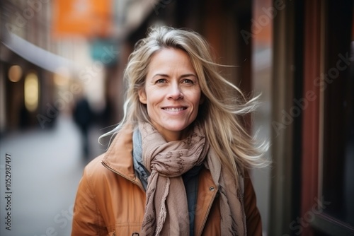 Portrait of happy mature woman walking in city street, smiling.