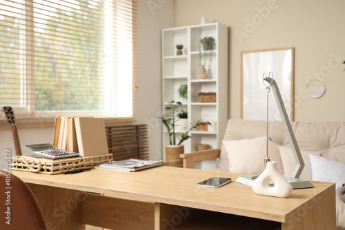 Workplace with books, mobile phone and pendulum in living room photo