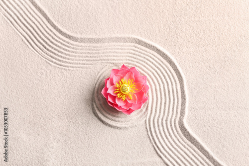 Beautiful flower on light sand with pattern. Zen concept