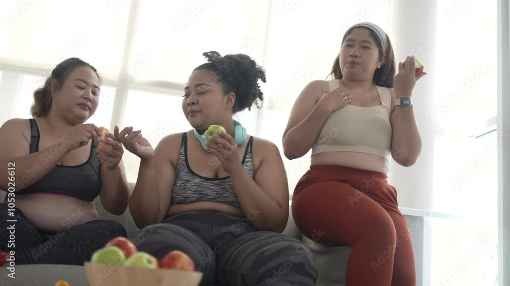 Plus size women eat apples at fitness center. Health care, lifestyle.
