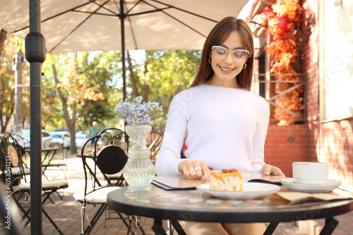 Young woman reading menu at...