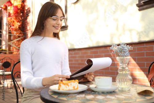 Young woman reading menu at...