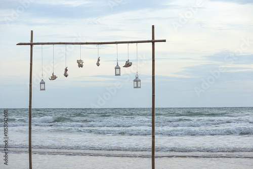 Natural seashell and lantern hanging on bamboo railing with blurred sea background. Concept enjoy the relaxing nature.