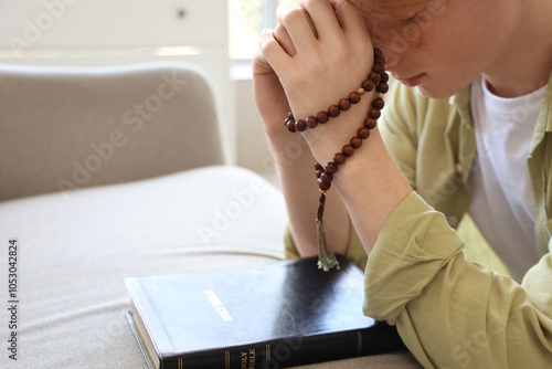 Teenage boy praying with be...