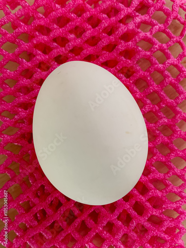 A white egg on a wood table