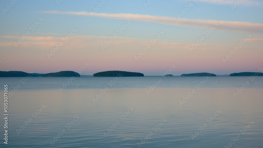 Tranquil Lake Under a Pastel Morning Sky with Distant Islands on the Horizon Tranquil Lake Under a Pastel Morning Sky with Distant Islands on the Horizon