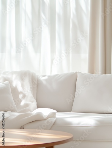 A cozy living room with a large white sofa, soft blankets, and pillows, a wooden coffee table, and natural light coming through large windows