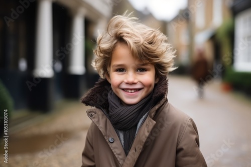 Portrait of a cute little boy with blond curly hair and brown coat