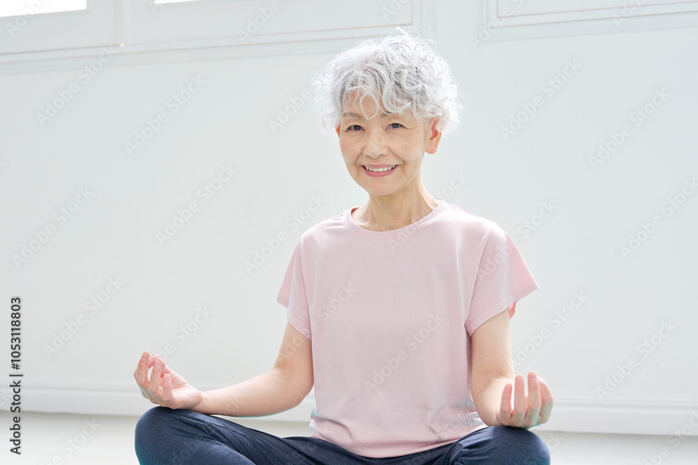 ヨガで坐禅をするシニア女性　カメラ目線