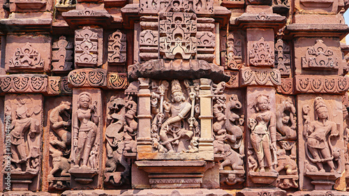 Sculptures of Lord Shiva in a dancing pose along with other Hindu deities on Nohta Temple, located in Nohta, Damoh, Madhya Pradesh, India. photo