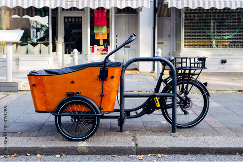 Photography Orange cargo bike parked on a london sidewalk