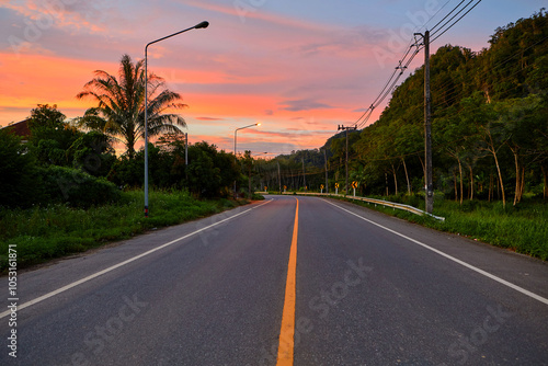 Silhouette of Dramatic sky during sunset over asphalt road photo