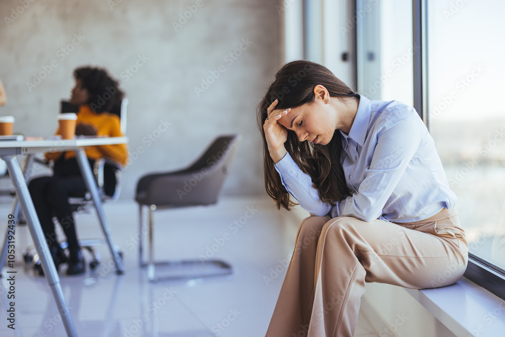 Fototapeta premium Stressed Businesswoman Sitting by Window in Office Environment