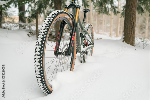 Mountain bike standing on snow in a forest during winter