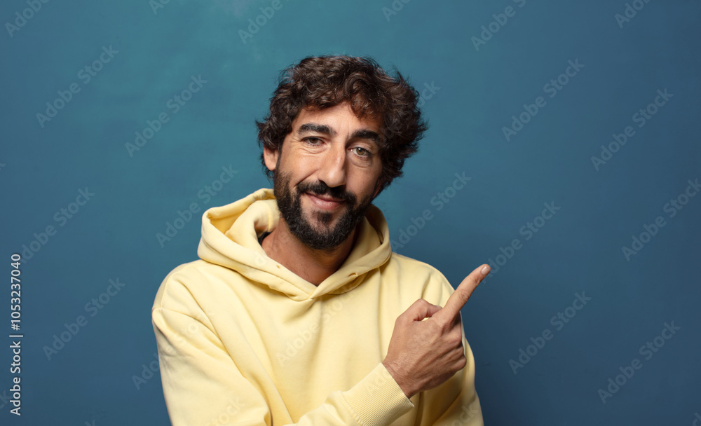 smiling cheerfully, feeling happy and pointing to the side and upwards, showing object in copy space smiling cheerfully, feeling happy and pointing to the side and upwards, showing object in copy space