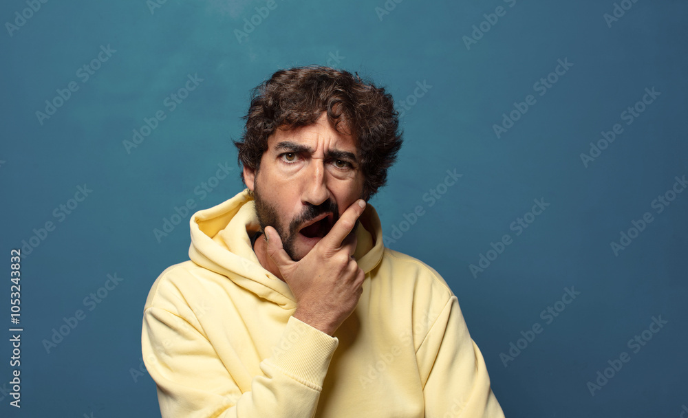 with mouth and eyes wide open and hand on chin, feeling unpleasantly shocked, saying what or wow with mouth and eyes wide open and hand on chin, feeling unpleasantly shocked, saying what or wow