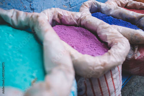 Bright moroccan dry paint in open sacks paint of different typical colors for sale on the old street market.Blue town Chefchaouen, Morocco.