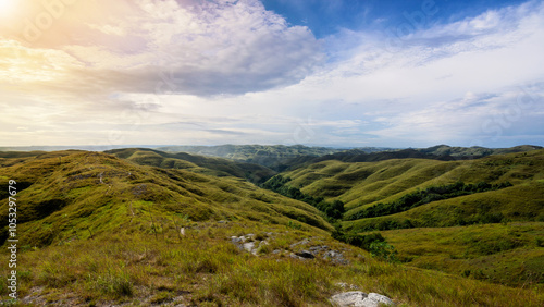 Mountain range with blue sky and clouds in the background. The sky is clear and the clouds are fluffy