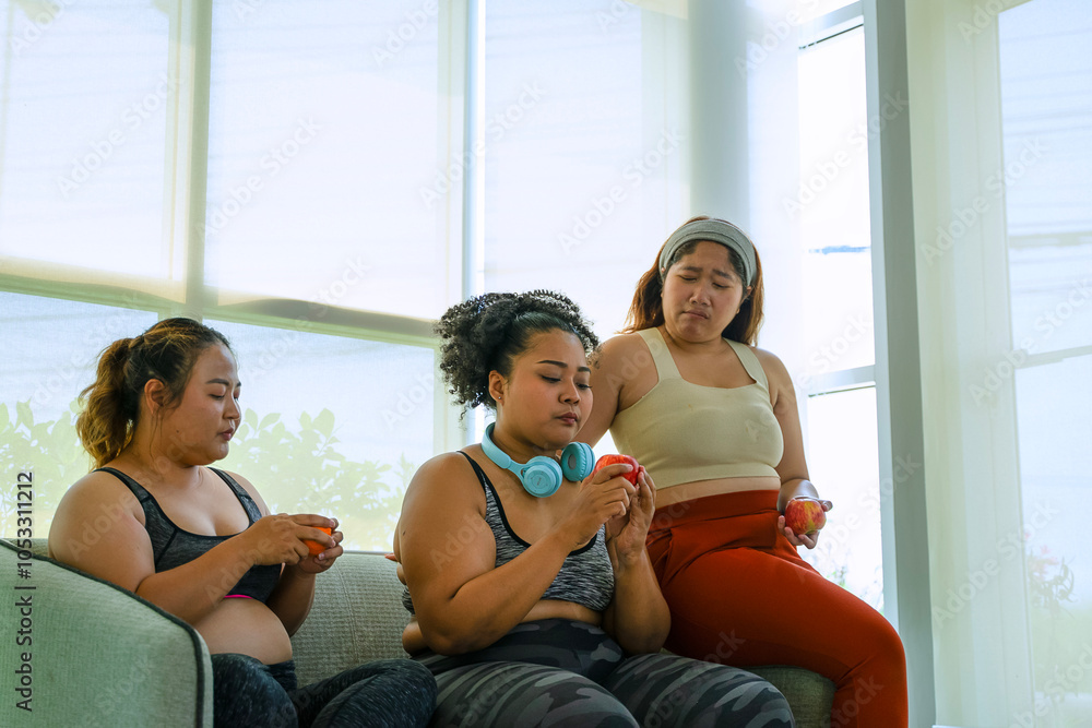 Plus size women eat apples at fitness center. Plus size women eat apples at fitness center.